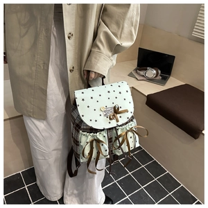 Detail of star print backpack with brown ribbon bows and drawstring front pockets