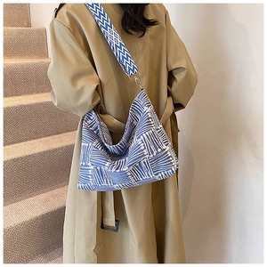 Detail of blue and white geometric woven tote bag with a matching wide shoulder strap