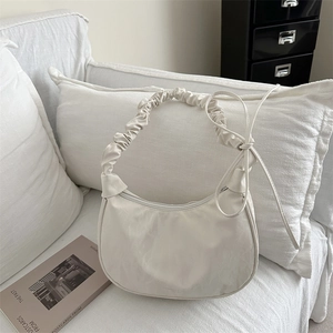 Chic beige crescent bag with ruched cloud handle and ribbon bow for minimalist style