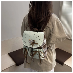 Detail of vintage mint green star backpack with plaid patchwork and bow decorations