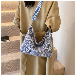 Detail of blue geometric print crossbody bag with stylish wide patterned shoulder strap
