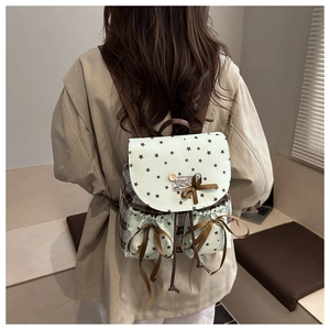 Close-up of mint green plaid backpack featuring bow details and star print on a model