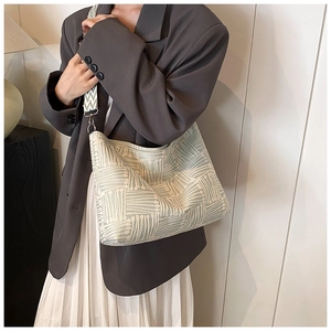 Dettaglio della borsa tote in tela a righe con ampia tracolla jacquard e fibbie metalliche