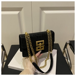 Macro shot of black suede shoulder bag with leopard pattern and gold geometric buckle