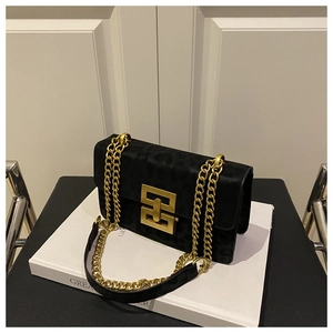 Detailed view of the gold geometric metal clasp and leopard pattern on black suede bag