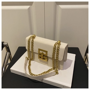 Detailed shot of white leather crossbody bag with gold chain and metal lock on book