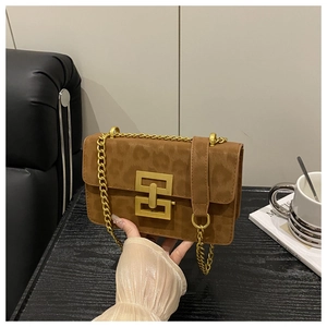 Close-up of brown leopard print crossbody bag with gold chain and geometric clasp
