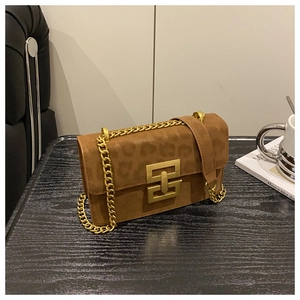 Detailed shot of leopard print crossbody bag featuring a gold square lock and chain strap
