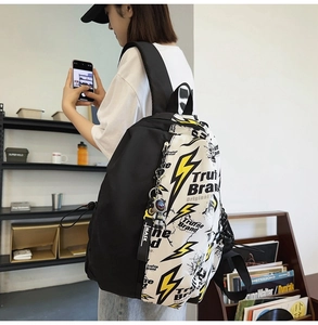 Close-up of a street style backpack with yellow lightning bolt pattern and astronaut charm