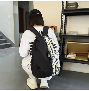 Detail of graffiti backpack with yellow lightning print and astronaut charm pendant