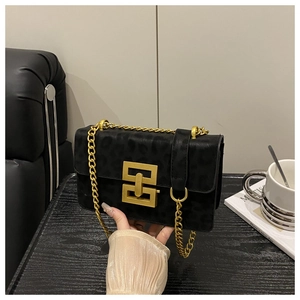 Detail of black leopard embossed crossbody bag with gold geometric buckle and chain
