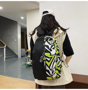 Detail of graffiti backpack with astronaut charm and large capacity side buckle design