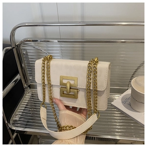 Detailed view of cream leather shoulder bag with vintage gold geometric metal clasp