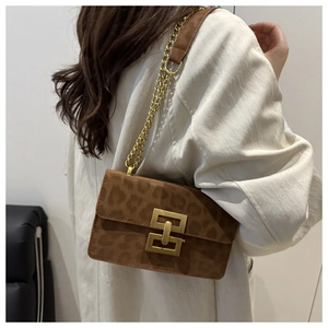 On-body view of vintage leopard print crossbody bag with gold chain and metal lock