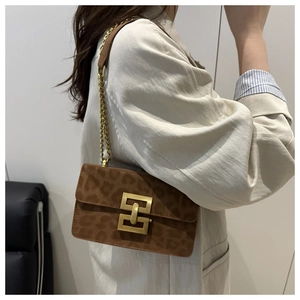 Side view of leopard print shoulder bag with gold geometric buckle and chain strap on model