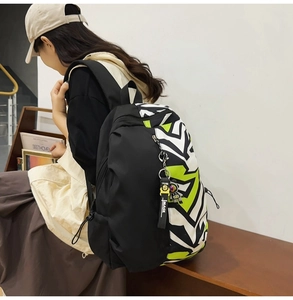 Detail of graffiti pattern backpack with astronaut charm and colorful side panels