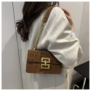 Detail view of brown leopard print crossbody bag with gold chain and metal lock