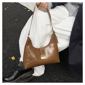 Detail of caramel brown glossy faux leather hobo bag with elegant metal square buckle