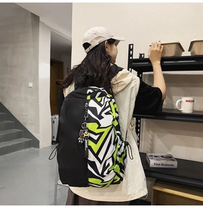Detail of graffiti patchwork backpack with neon green accents and MASK keychain