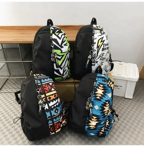Detail view of four graffiti pattern backpacks with astronaut charms and zip closure