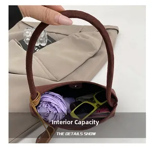 Internal capacity of brown suede tote bag showing storage for umbrella and sunglasses