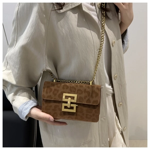 Detail of vintage leopard print crossbody bag with gold geometric clasp and chain strap