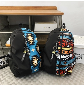 Detailed view of color-block nylon backpacks featuring geometric prints and astronaut charms