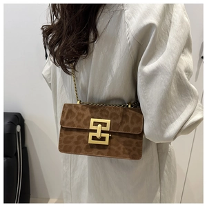 Close-up of leopard print shoulder bag featuring a gold geometric lock and chain strap