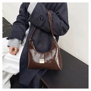 Detail of the vintage dark brown leather hobo bag featuring a gold buckle and adjustable strap