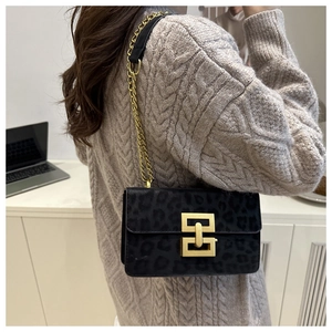 Close-up of leopard print crossbody bag with gold geometric buckle and chain strap