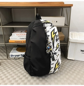 Detail of trendy graffiti backpack with lightning print and astronaut keychain accessory