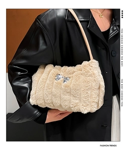 Détail du sac à bandoulière beige en fausse fourrure avec nœud argenté élégant