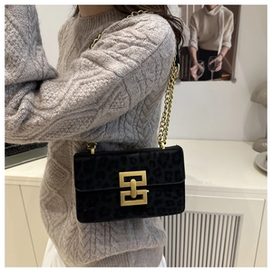 Close-up of black leopard print bag with gold chain strap and geometric metal buckle