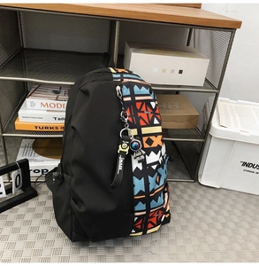 Detail of graffiti backpack with colorful geometric patterns and astronaut pendant charm