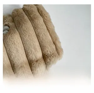 Détail macro de la texture en fausse fourrure camel clair avec maillon argenté