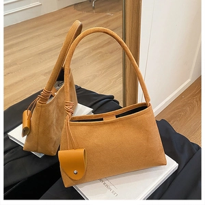 Vue détaillée du sac cabas en daim caramel avec poignée en cuir et charm décoratif