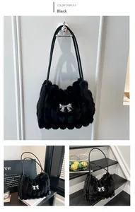 Close-up of black plush faux fur shoulder bag with silver metallic bow detail