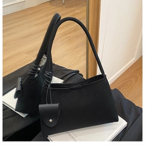 Détail du sac porté épaule en feutre noir avec sa pochette décorative assortie attachée