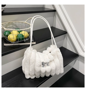Détail d'un sac à bandoulière en fausse fourrure blanche avec nœud argenté chic