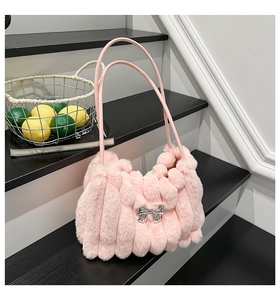 Détail d'un sac en peluche rose avec rayures verticales en fourrure et nœud argenté