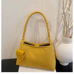 Detail of yellow suede underarm bag with matching mini coin purse and minimalist design