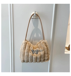 Détail du sac bandoulière en peluche abricot avec fausse fourrure et nœud métallique