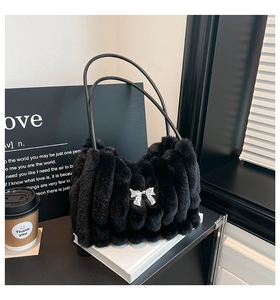 Détail du sac à bandoulière en fausse fourrure noire avec nœud argenté et rayures verticales
