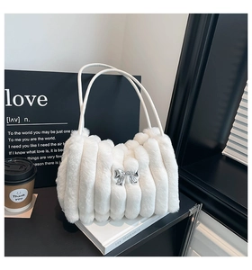 Détail du sac en fausse fourrure blanche avec plis verticaux et nœud en métal argenté