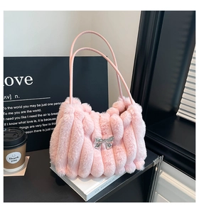 Gros plan détaillé d'un sac à main en fausse fourrure rose avec nœud argenté décoratif