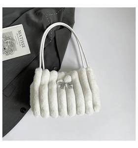 Détail du sac à bandoulière en fausse fourrure blanche avec plis et nœud argenté