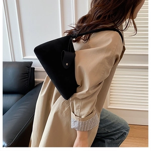 Gros plan d'un sac cabas noir mat avec bandoulière nouée et petite poche latérale