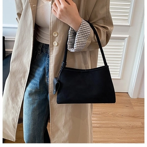 Minimalist black matte shoulder bag with a stylish knot and heart charm on the strap
