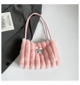 Détail du sac à main en fausse fourrure rose avec texture peluche et nœud argenté miroir
