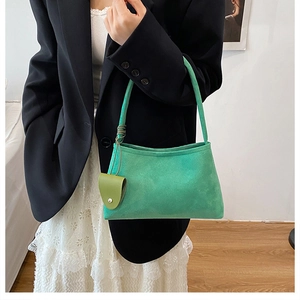 Détail d'un sac cabas en daim vert vif avec une mini pochette circulaire pour femme